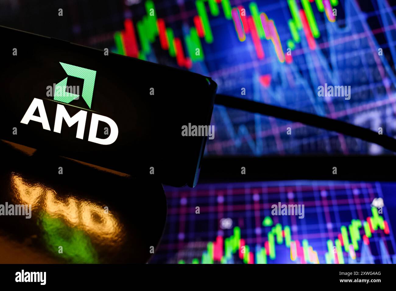 In dieser Fotoabbildung wird das AMD-Logo auf einem Smartphone-Bildschirm vor einem Computerbildschirm angezeigt, der Aktiendiagramme am 19. August 2024 anzeigt, während sich die Aktienmärkte nach einem Rückschlag Anfang August stabilisieren. Stockfoto