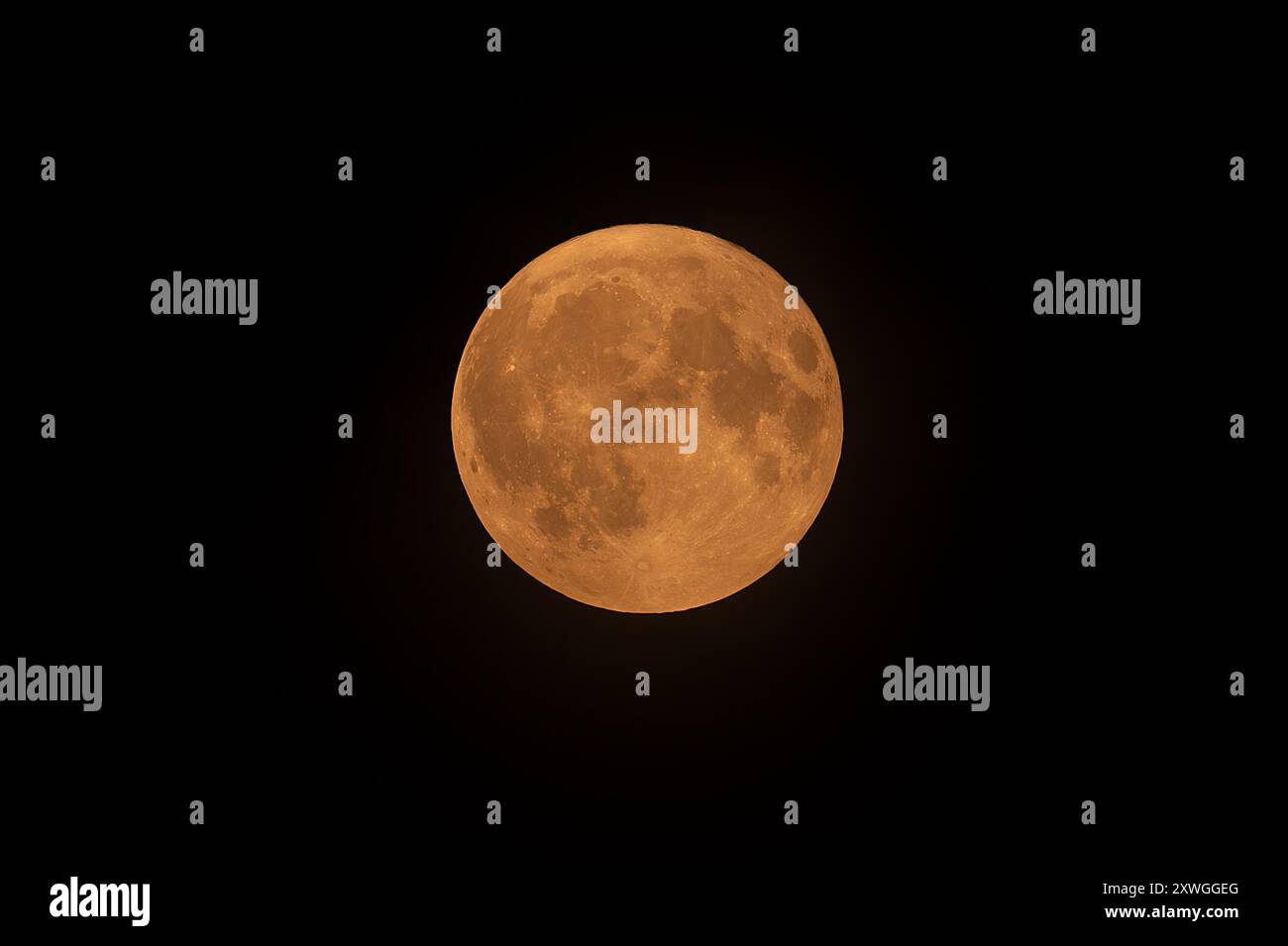 Blauer Vollmond über Belgien leuchtet rot, weil der nordamerikanische Wildbrand am 19. August 2024 in der Atmosphäre verraucht wurde Stockfoto