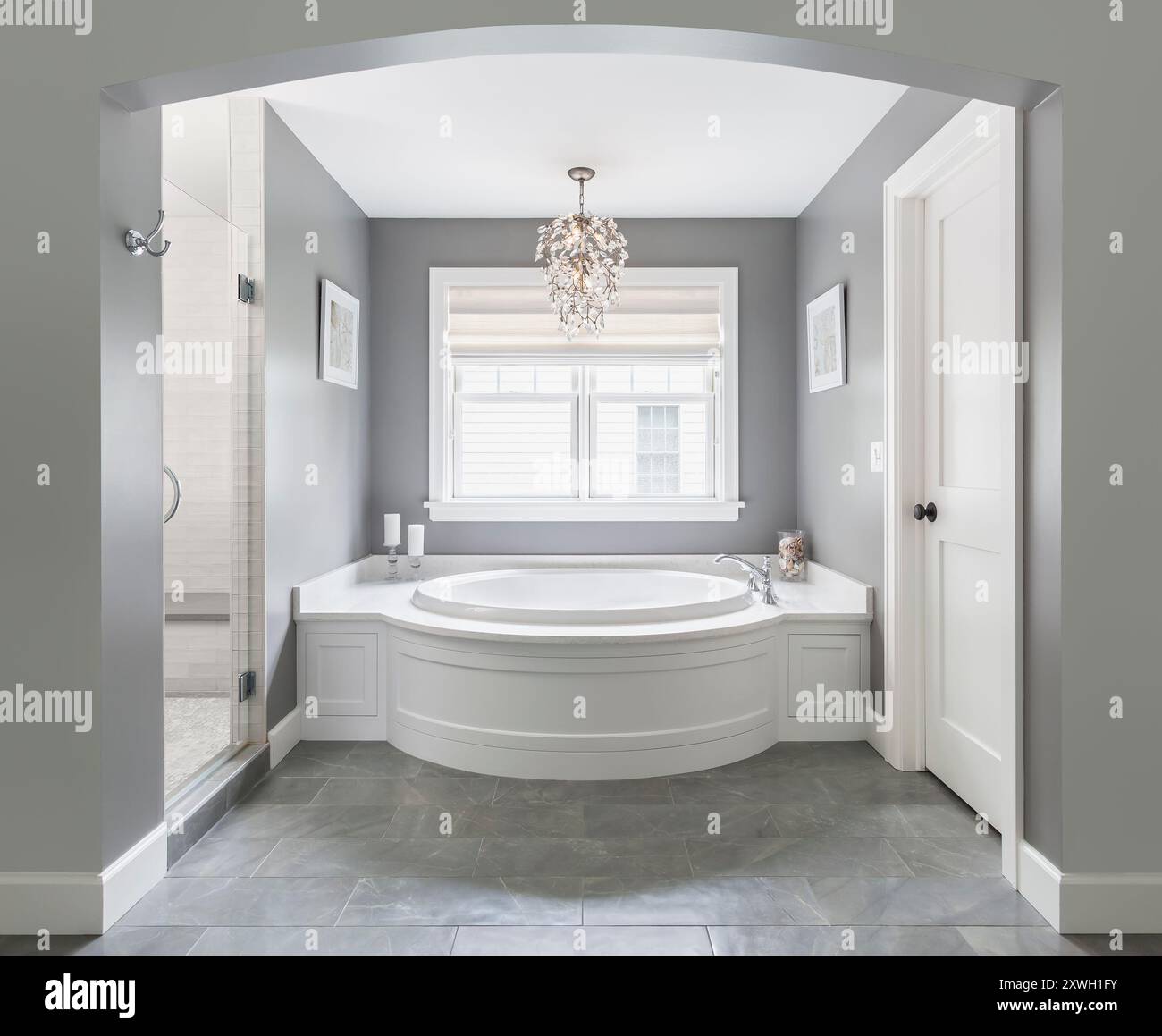 Hauptbadezimmer mit großer eingebauter Badewanne und begehbarer Dusche Stockfoto