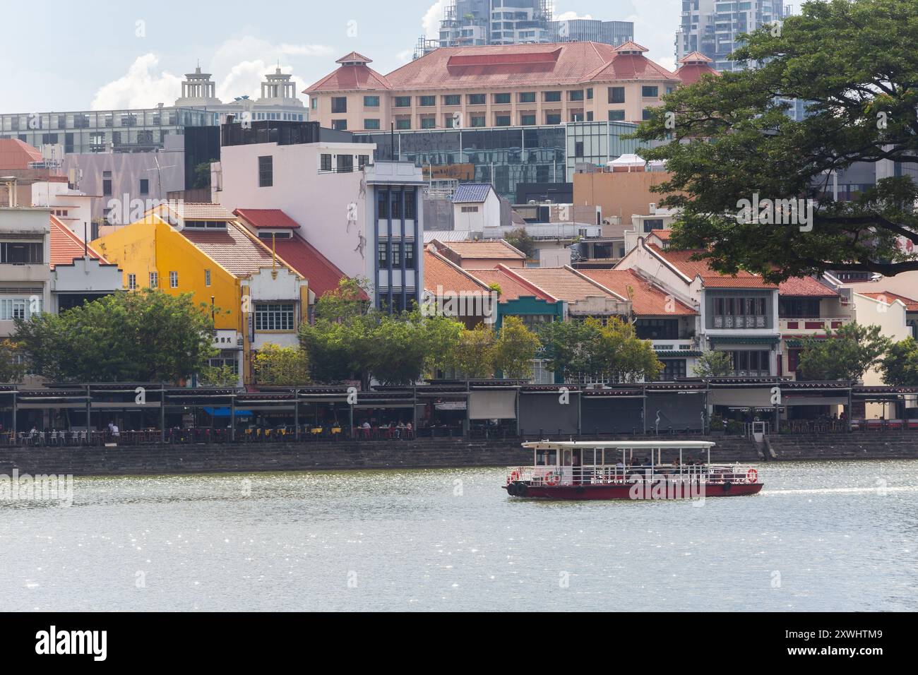 19. August 2024 Fähren fahren entlang der Boat Quay Shophouses. Hauptsächlich ein Transport, um Touristen in der Gegend um den Singapore River zu zeigen. Singapur. Stockfoto