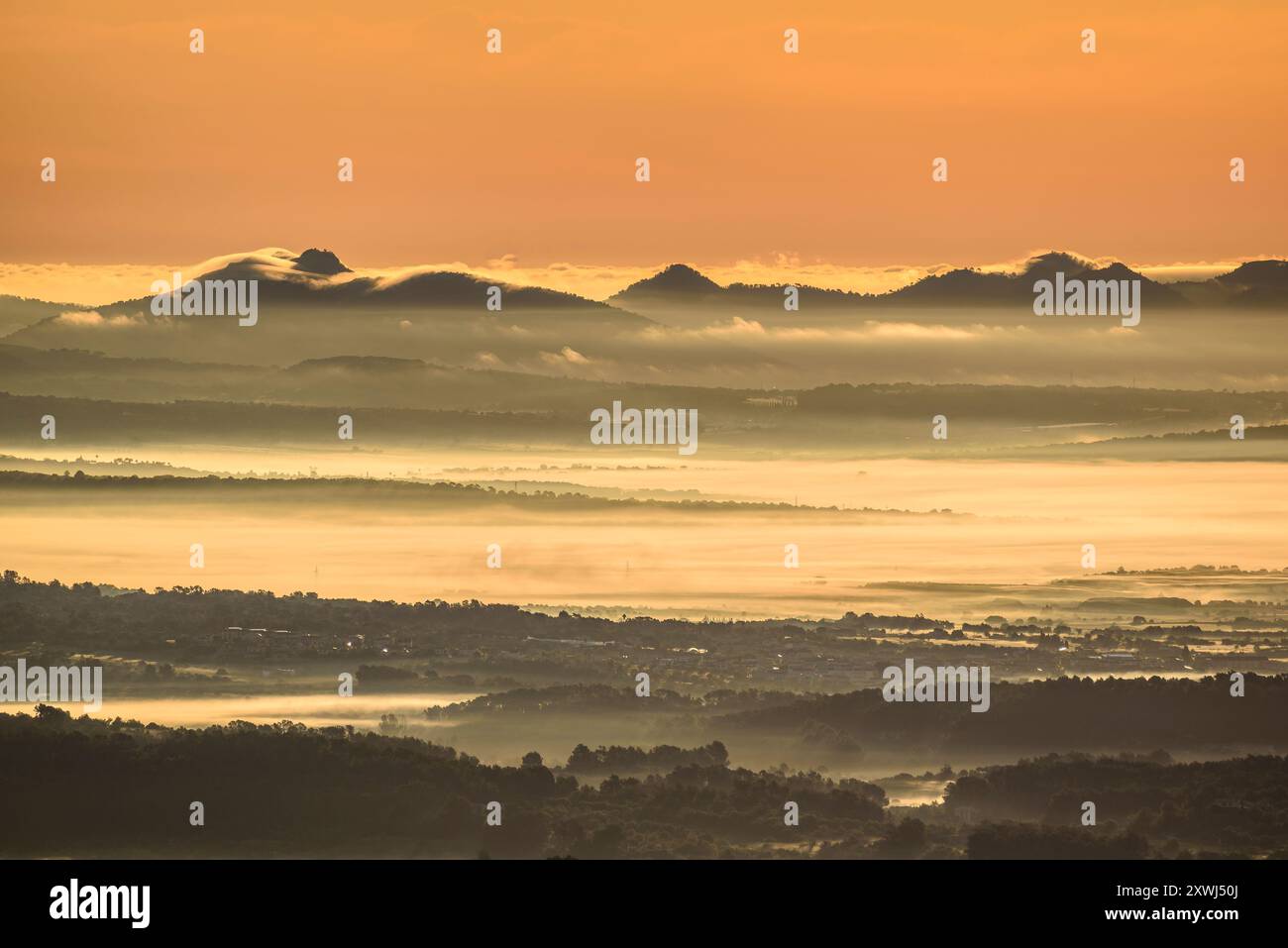 Sonnenaufgang von Puig de Randa aus gesehen, Blick auf die Serres de Llevant (östliche Gebirgszüge) mit Morgennebel (Mallorca, Balearen, Spanien) Stockfoto