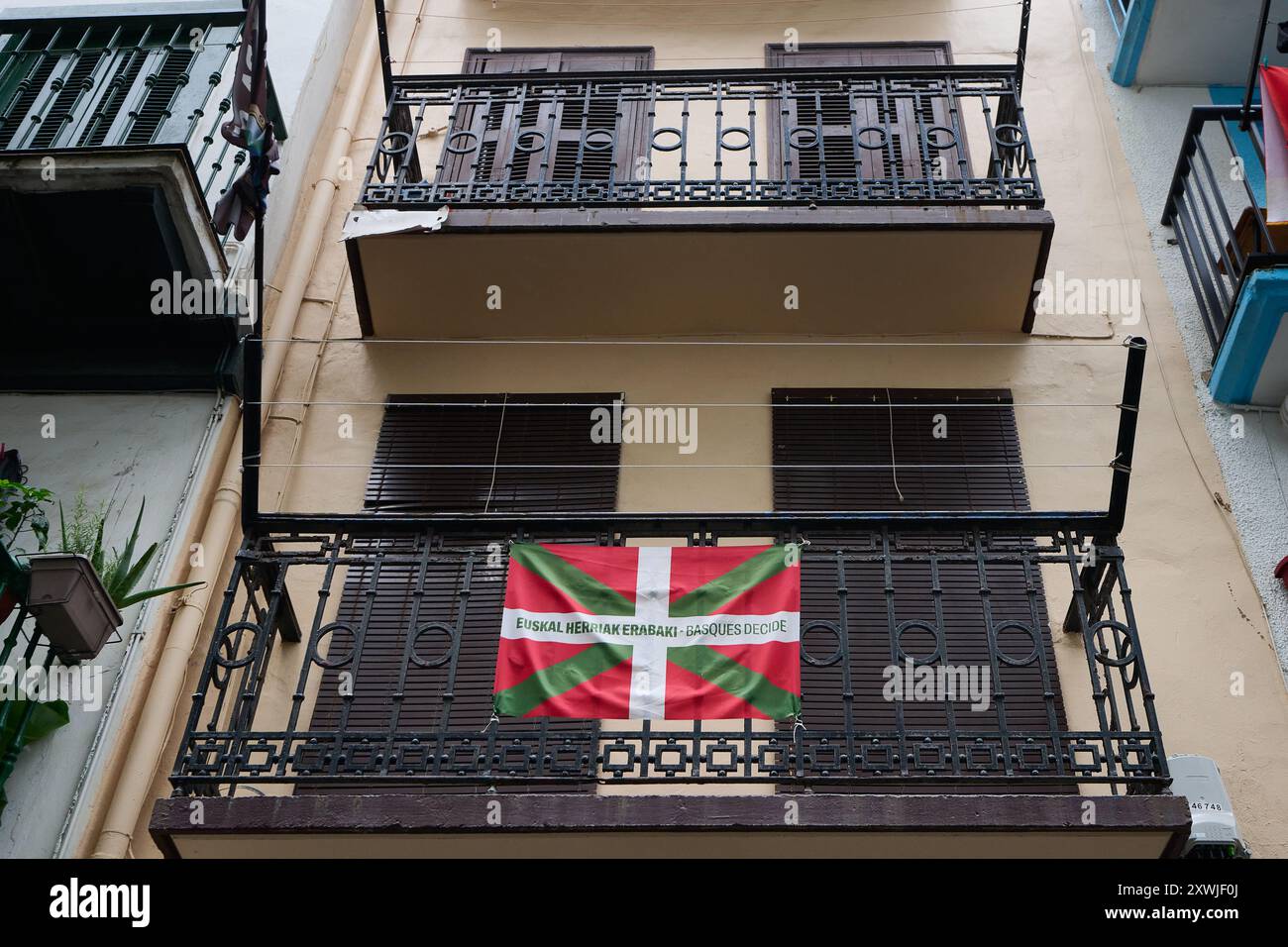 Flagge des Baskenlandes auf einem Balkon mit einem Slogan für die Unabhängigkeit Stockfoto