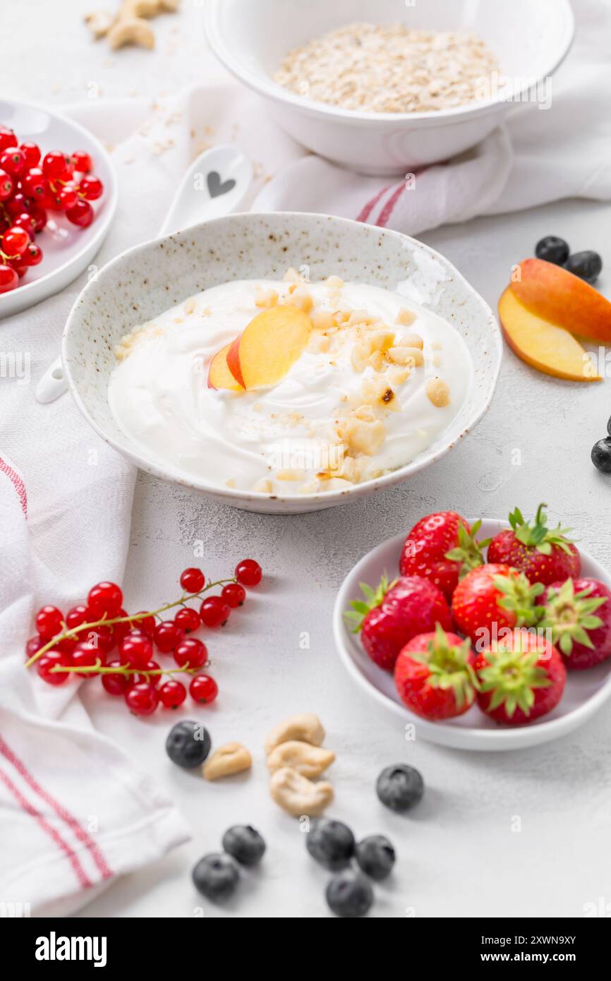 Griechischer Joghurt mit verschiedenen Beeren, Nüssen und Haferflocken Stockfoto