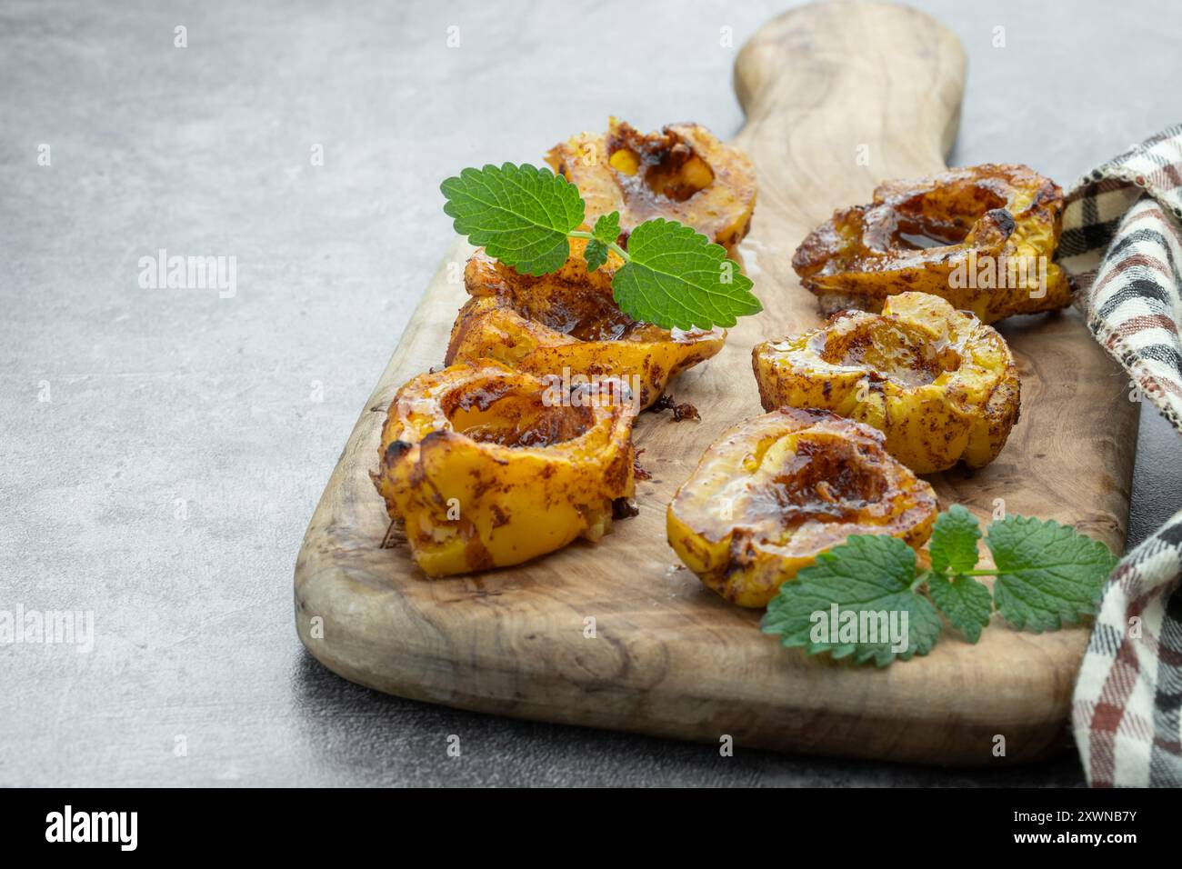 Köstliches und gesundes Dessert aus gebackener Quitte mit Honig und Gewürzen auf grauem Hintergrund Stockfoto Köstliches und gesundes Dessert aus gebackener Quitte mit Honig und Gewürzen auf grauem Hintergrund Stockfoto