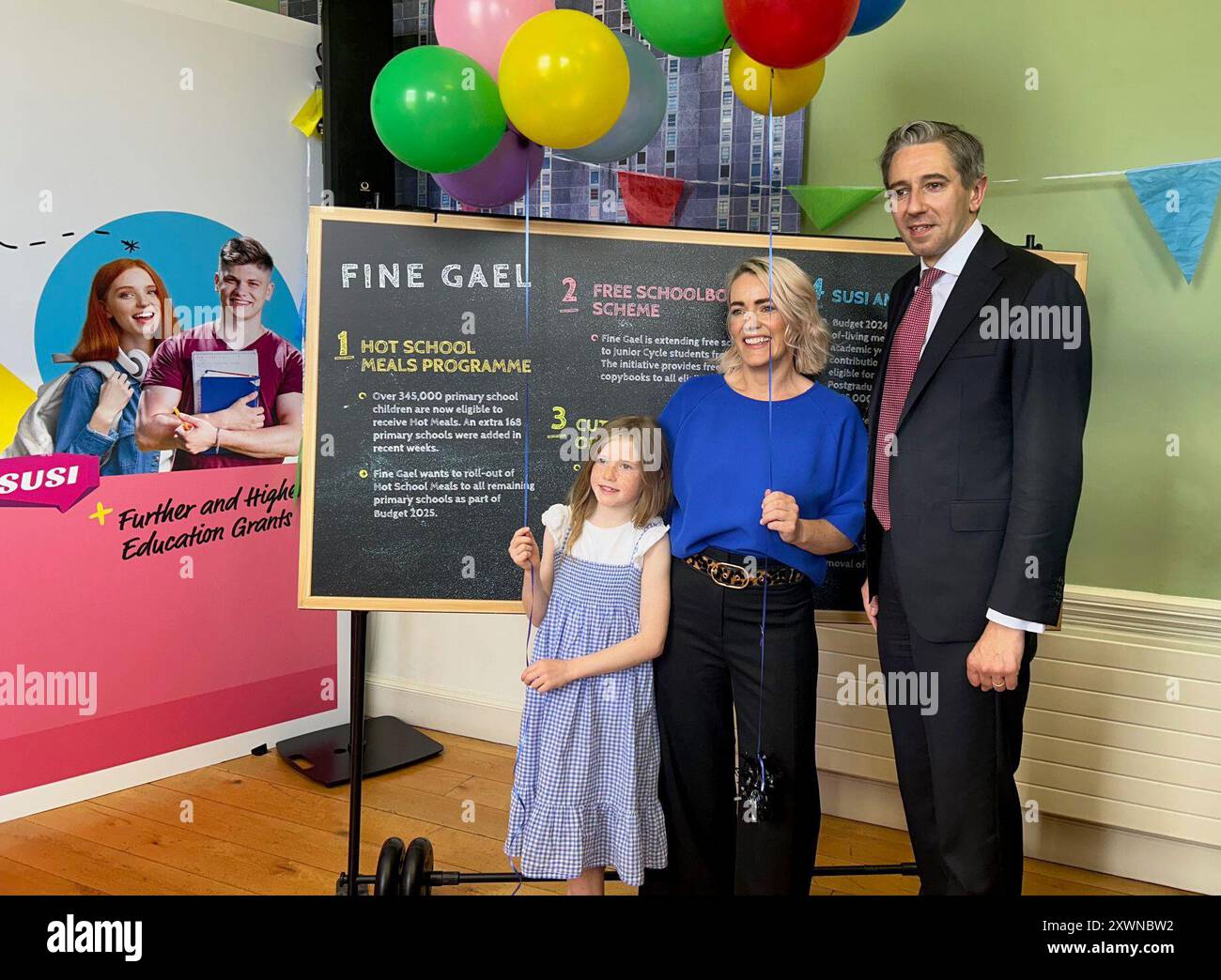Ein Taoiseach Simon Harris mit Stadträtin Emma Blain und ihrer Tochter Tilly Macken bei einer Fine Gael Veranstaltung in Dublin, die sich auf Eltern und berufstätige Familien konzentrierte. Harris möchte untersuchen, wie Kinder außerhalb der Schulzeit warme Schulmahlzeiten erhalten können, um den „Urlaubshunger“ in benachteiligten Familien zu bekämpfen. Bilddatum: Dienstag, 20. August 2024. Stockfoto