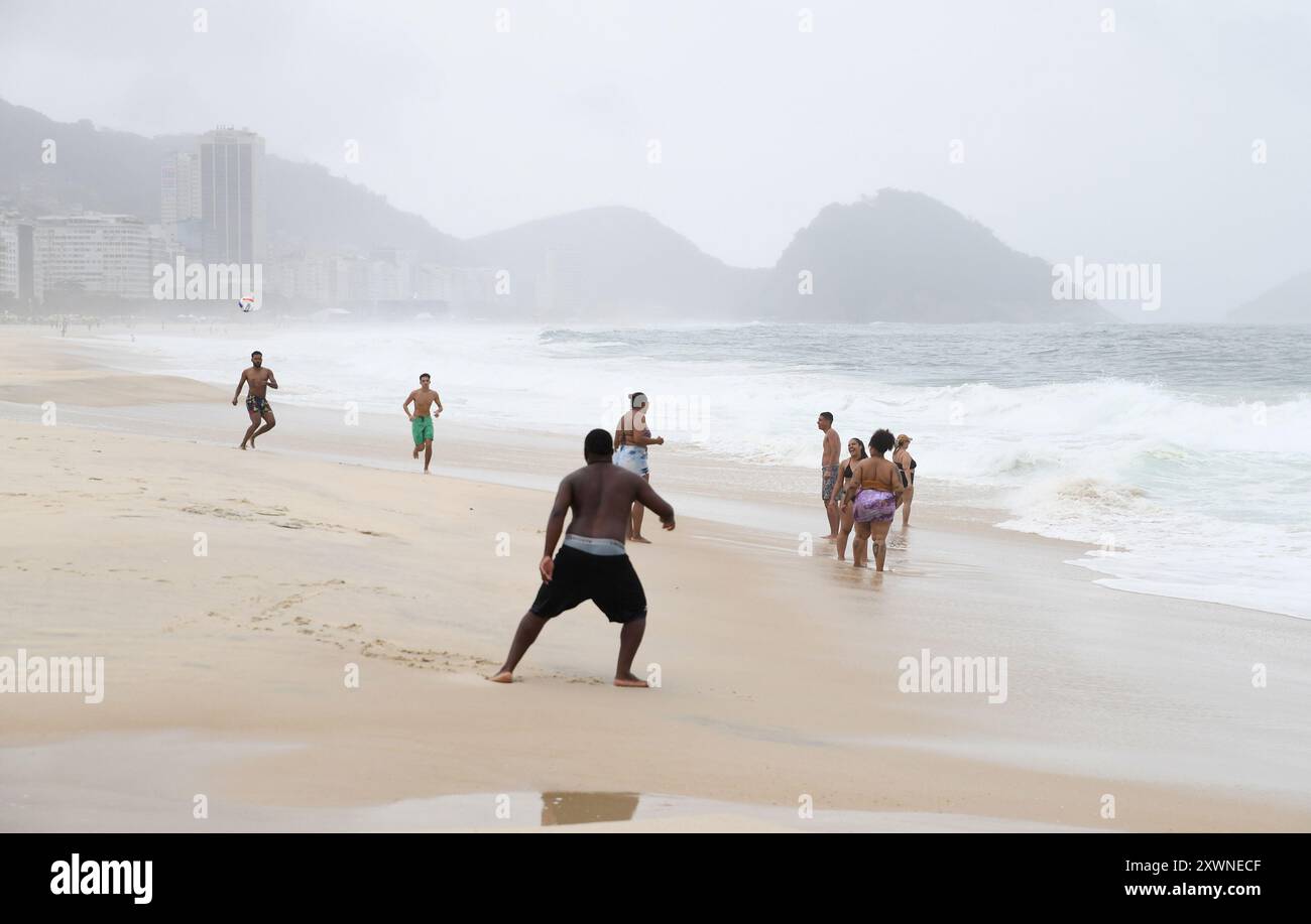 Die Leute genießen sich am Copacabana Beach trotz des trostlosen Wetters Stockfoto