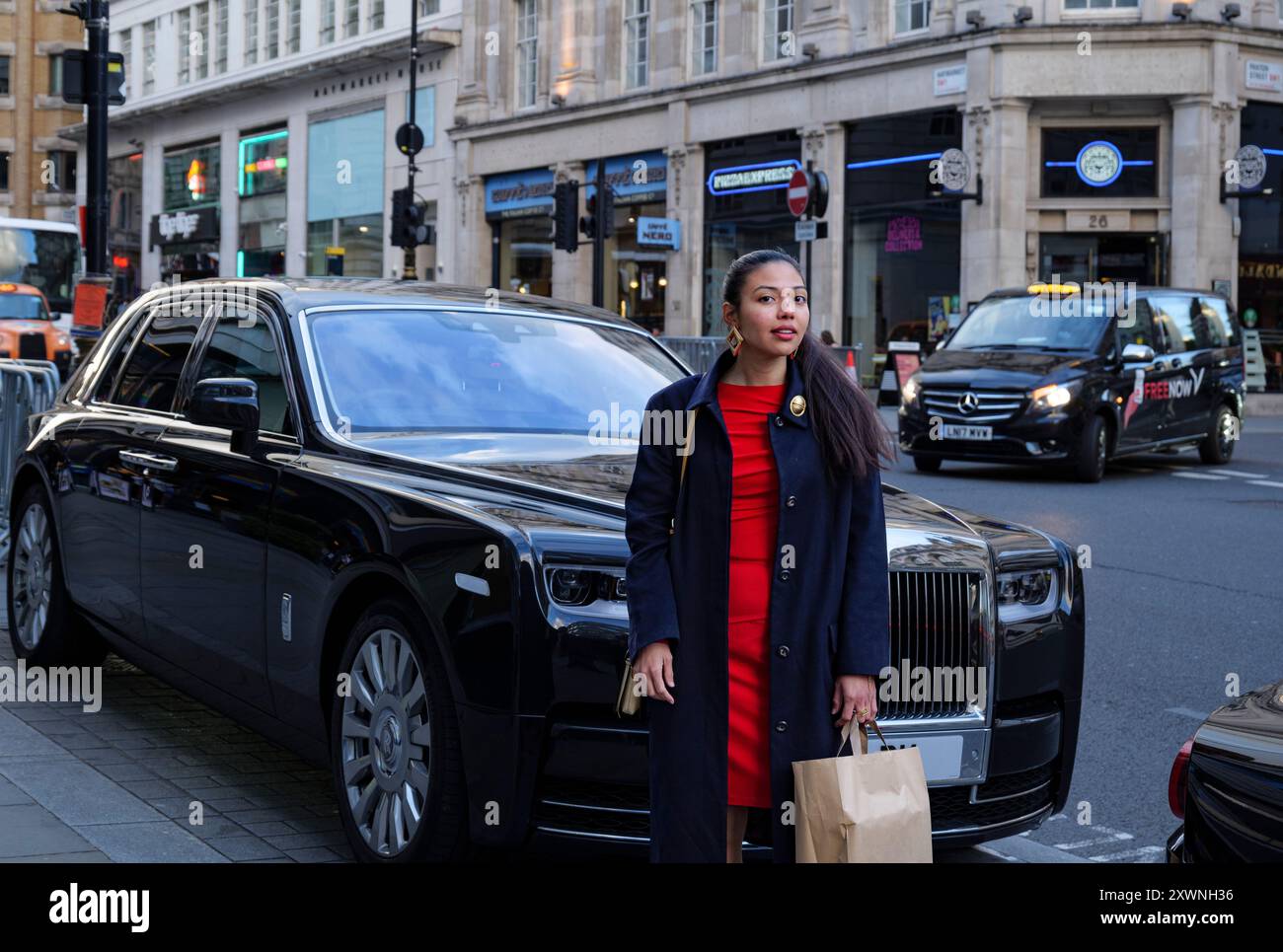 London - 06 11 2022: Mädchen hält nach dem Einkaufen vor einem Luxusauto an Stockfoto