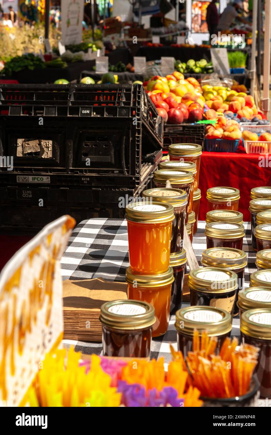 Tische mit Honig und Obst auf einem Bauernmarkt in der Nachbarschaft. Stockfoto