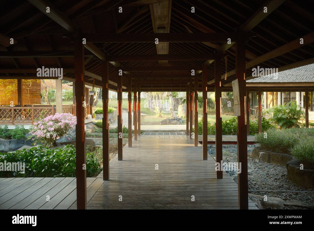 Pavillon mit Holzgang, umgeben von traditioneller Architektur und japanischem Garten Stockfoto