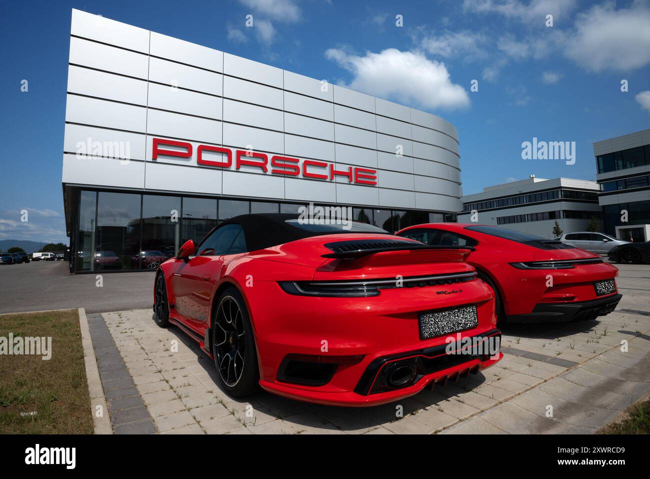Porsche-Händler mit zwei roten Porsche-Fahrzeugen, darunter ein 911 Turbo S, Plattling, Niederbayern, Deutschland Stockfoto