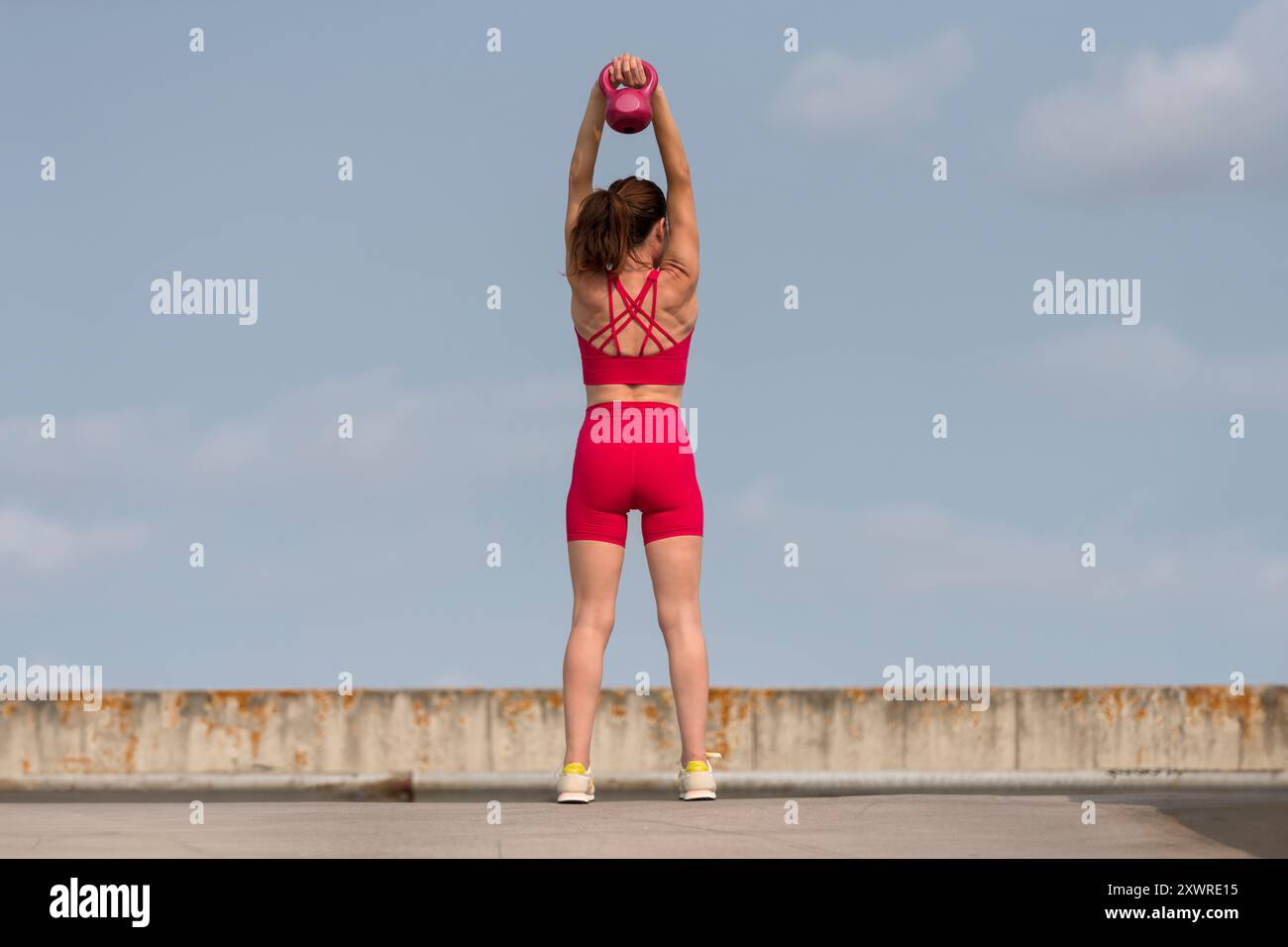 Sportliche Frau mit Hantelgewicht, Outdoor, urbaner Hintergrund Stockfoto