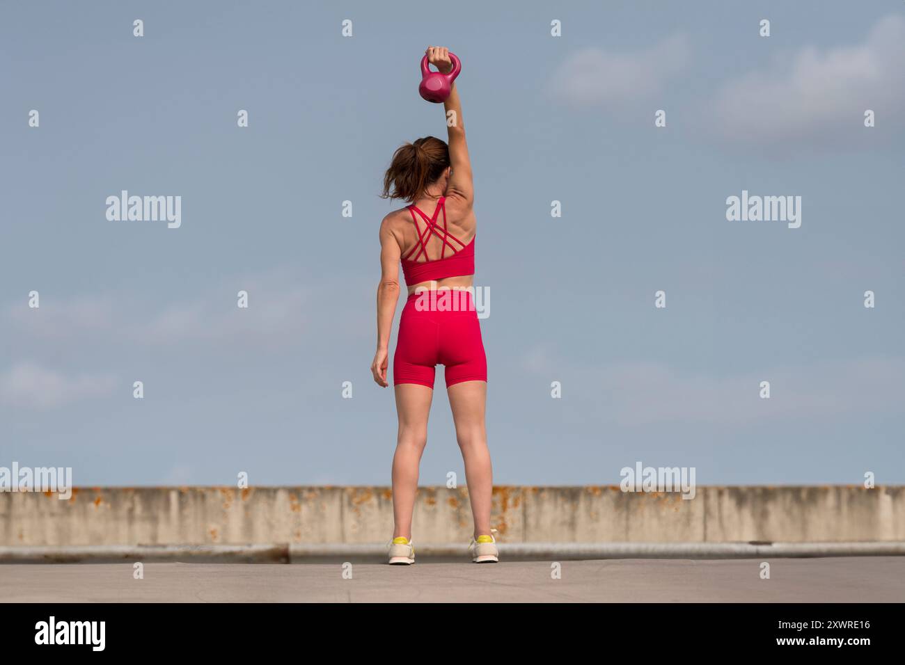 Sportliche Frau mit Hantelgewicht, Outdoor, urbaner Hintergrund Stockfoto