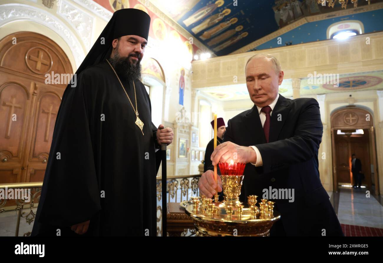 Baku, Aserbaidschan. August 2024. Der russische Präsident Wladimir Putin zündet eine Kerze neben dem Bischof von Baku und Aleksij Smirnow, links, während eines Besuchs in der Heiligen Myrrrhträgerkirche am 19. August 2024 in Baku, Aserbaidschan. Quelle: Vyacheslav Prokofyev/Kreml Pool/Alamy Live News Stockfoto