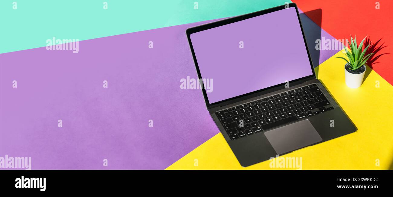 Laptop auf farbigem Hintergrund. Bildschirm löschen. Horizontales Banner. Kopierbereich. Elektronisches Heimgerät. Stockfoto