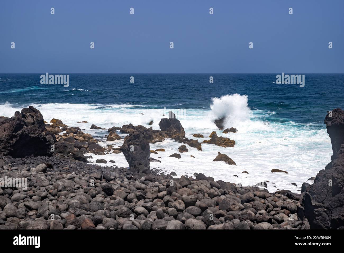 An einem schönen Sommertag brechen Wellen an der zerklüfteten Küste von Tenesera, Lanzarote Stockfoto