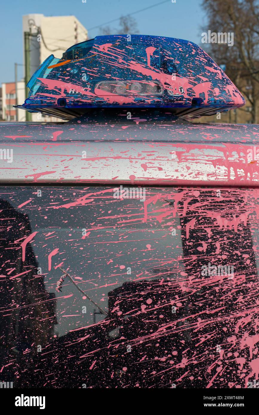 Ein abgerissener Polizeiwagen, der nach den Unruhen in Frankfurt mit pinkfarbenen Farbspritzern bedeckt war. Das Bild zeigt die Folgen der Unruhen und dient als Metapher für Chaos und Unruhe. Stockfoto