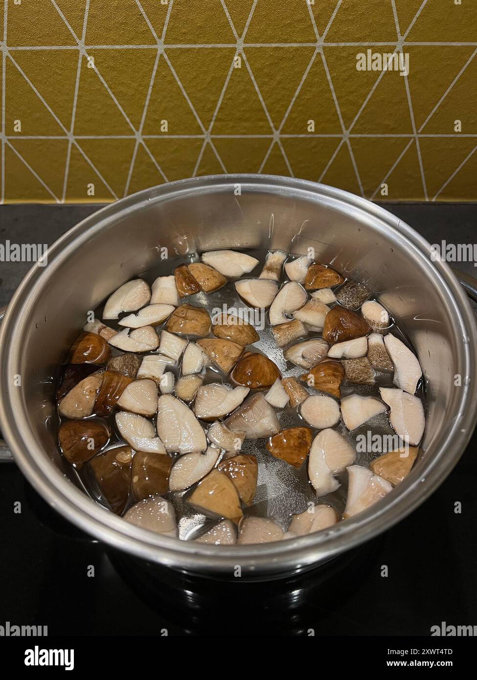 Gehackte Wildpilze werden in einer Pfanne in der Küche gekocht. Stockfoto