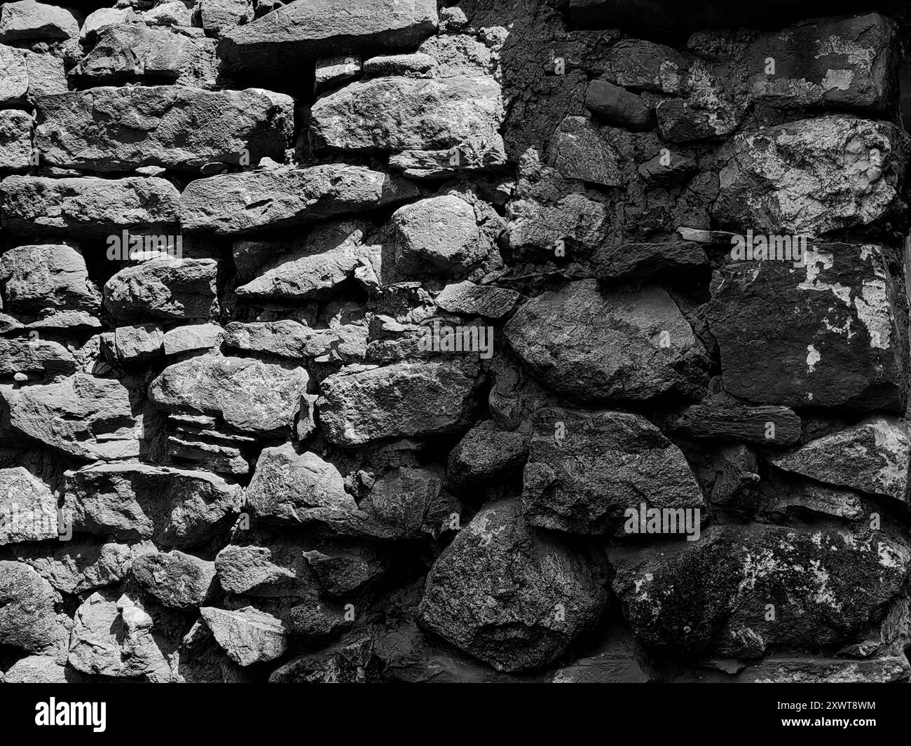 Alter Steinmauerhintergrund geteilt durch Sonnenlicht: Licht und Schatten – Dualitätskonzept. Schwarz-weiß. Stockfoto Alter Steinmauerhintergrund geteilt durch Sonnenlicht: Licht und Schatten – Dualitätskonzept. Schwarz-weiß. Stockfoto