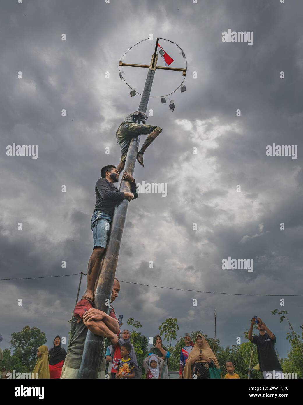 Balikpapan, Indonesien - 18. August 2024. Panjat Pinang oder Palmenkletterwettbewerb ist eine beliebte indonesische Tradition, die oft als Wettkampf ausgetragen wird Stockfoto