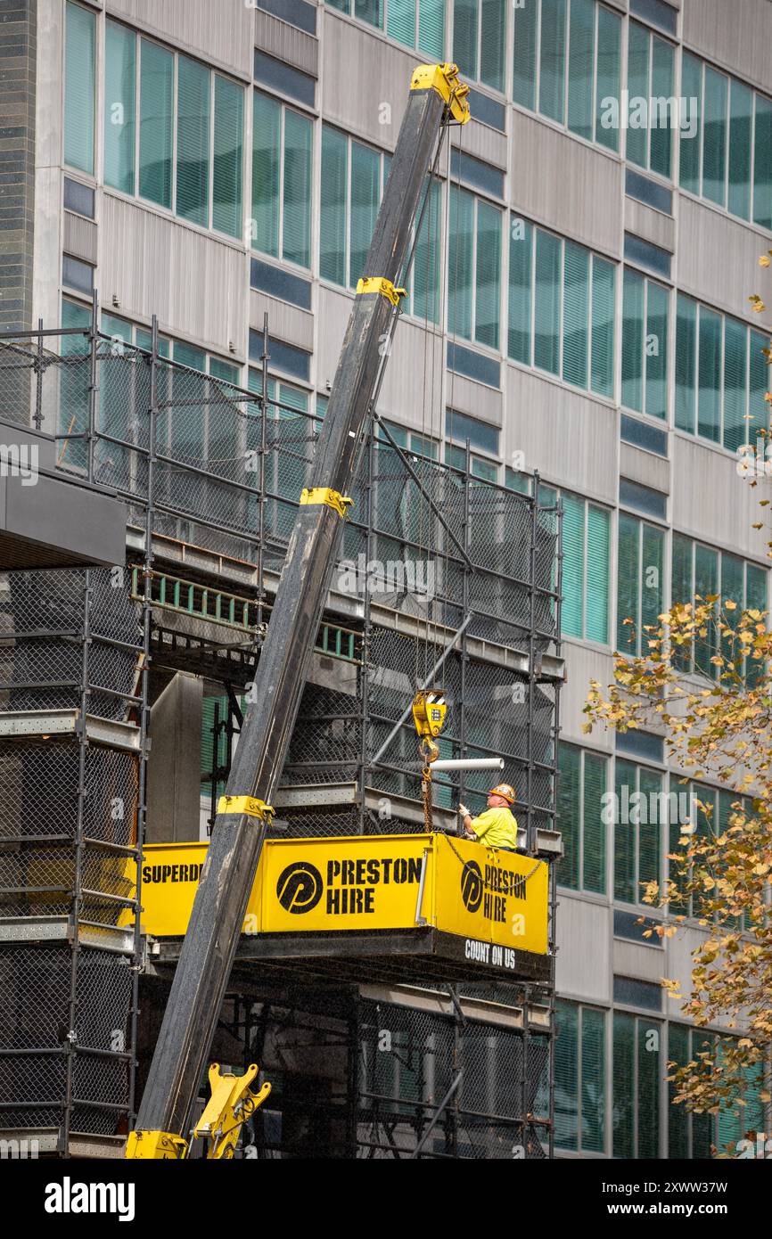 Sydney, NSW, Australien - 8. Mai 2024. Ein Rigger mit PSA lädt einen Kranhaken auf einer Baustelle in Downtown North Sydney. Stockfoto