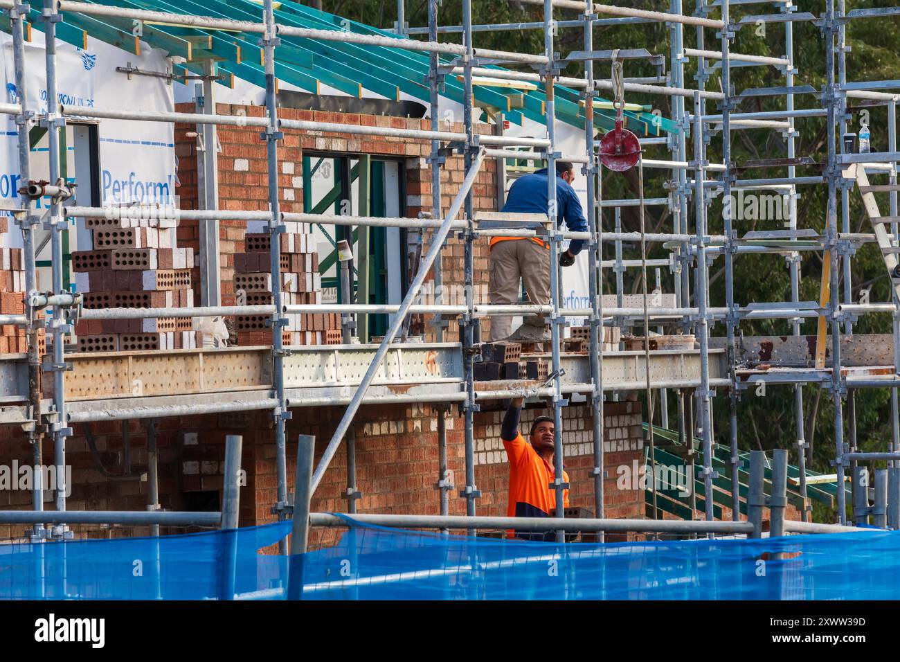 Sydney, NSW, Australien - 21. August 2024. Handwerker legen Ziegelsteine in einer neuen Wohnsiedlung in Sydneys äußeren Vororten. Stockfoto