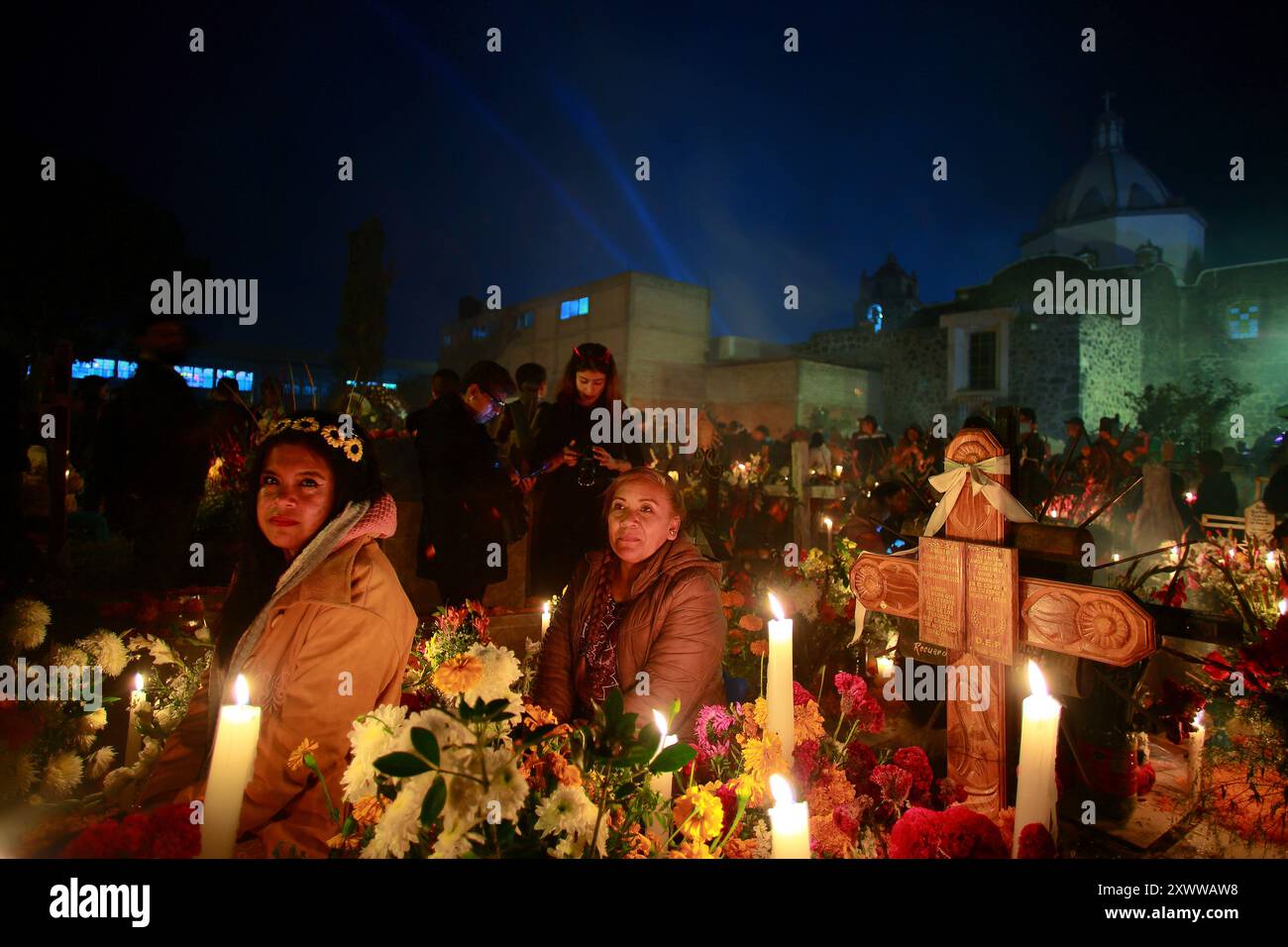 Ciudad de Mexico, Mexiko - 2. November. 2023: Frauen posieren für ein Foto vor einem Grab seines Verwandten auf dem Mixquic-Friedhof Stockfoto