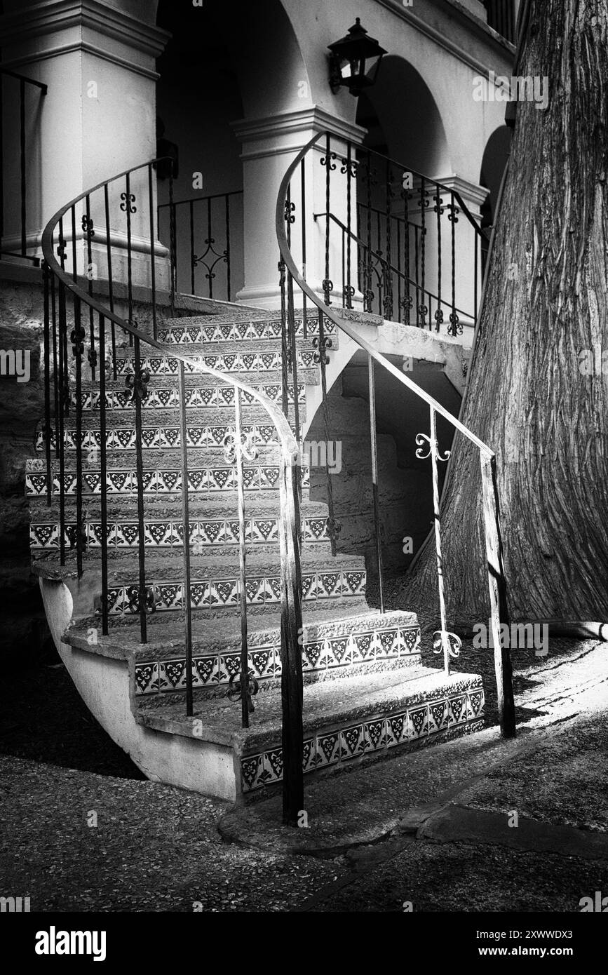 Schmiedeeiserne Treppe eines traditionellen Gebäudes in Schwarz-weiß mit Lichtstrom, Riverwalk, San Antonio, Texas Stockfoto