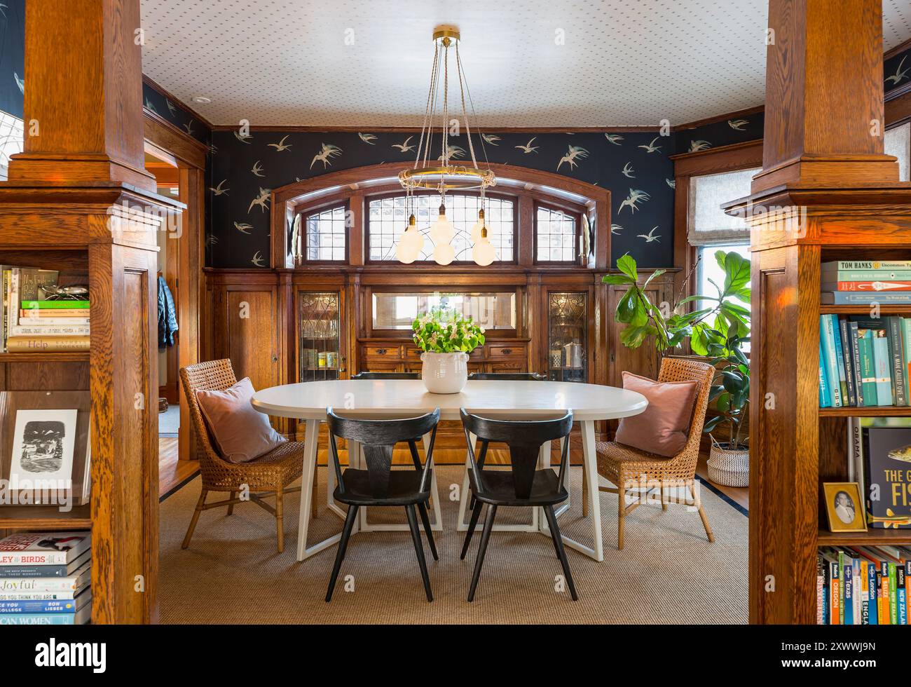 Speisesaal mit schönen Holzarbeiten an den Eingangsregalen und eingebautem Buffet mit modernem Esstisch und Stühlen Stockfoto