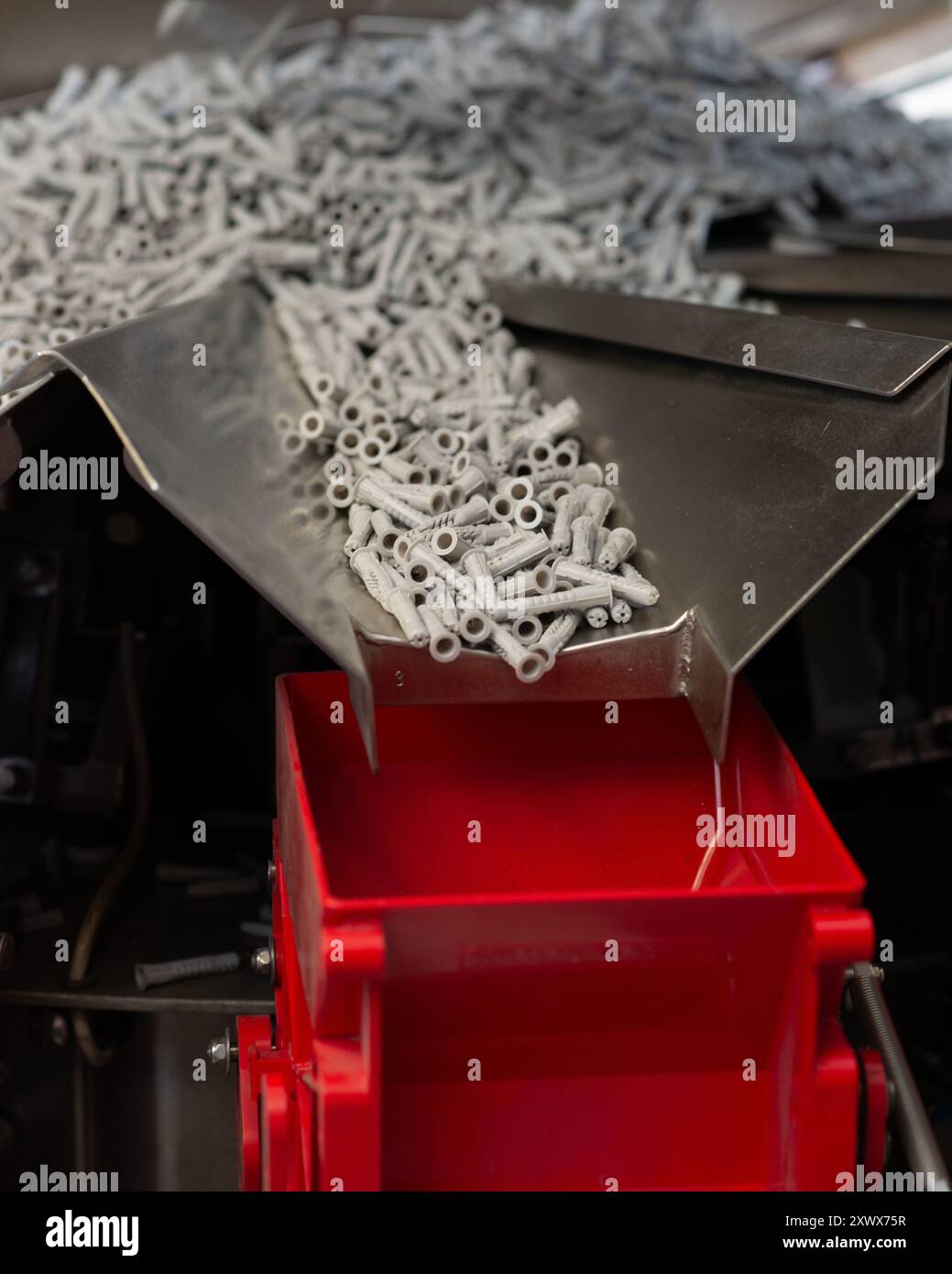 Nahaufnahme der Fischerwerke in Waldachtal, Baden-Württemberg, mit der industriellen Herstellung von Kunststoffdübeln. Das Bild zeigt den effizienten Fertigungsprozess und vermittelt ein Gefühl von Präzision und Massenproduktion. Stockfoto