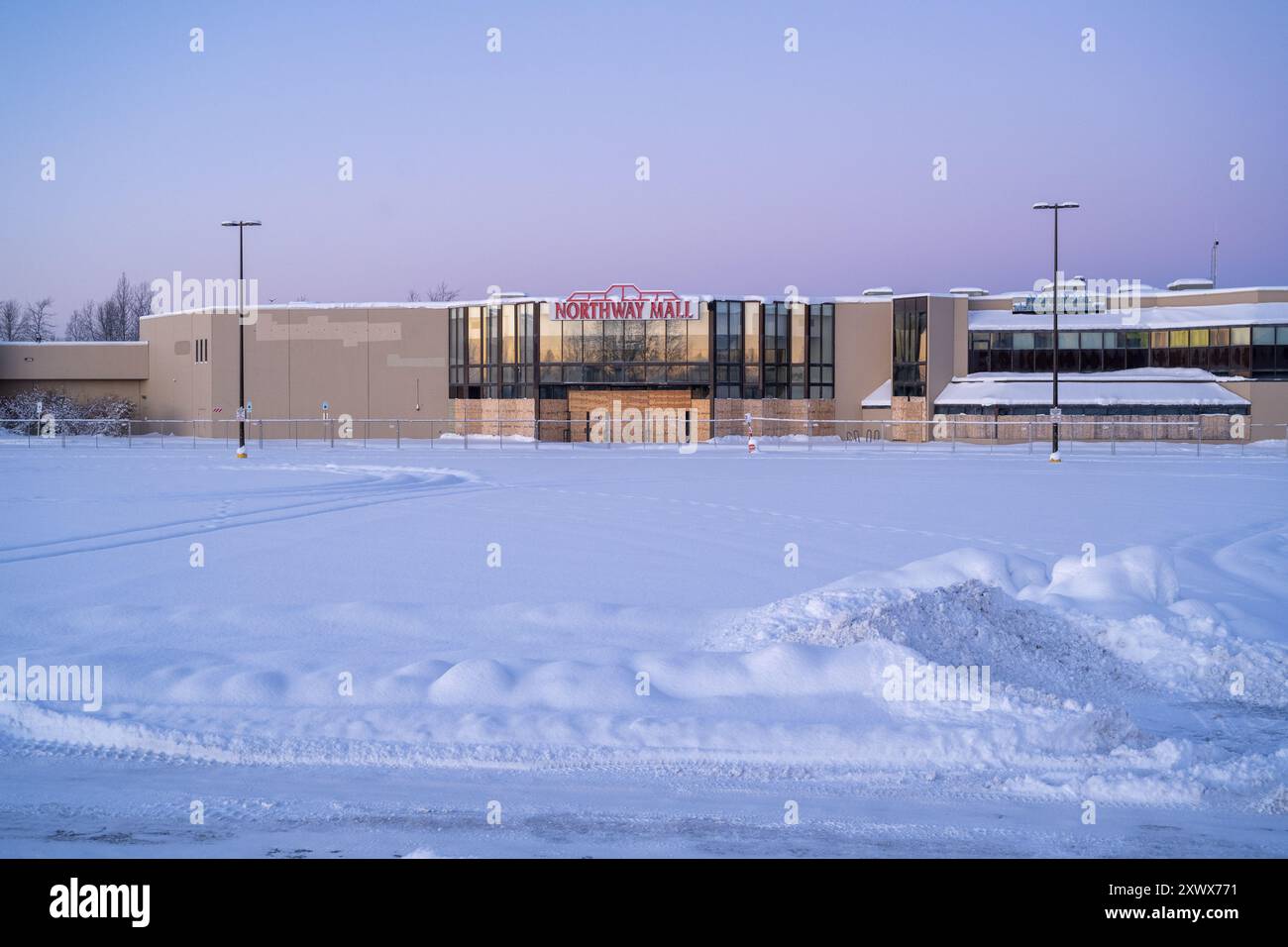 Ein leerer, schneebedeckter Parkplatz der Northway Mall in Anchorage, Alaska, zeigt die Stille und Kälte des Winters in der Nähe des Merrill Field Airport in Anchorage, Alaska. Die Szene weckt Gefühle von Einsamkeit und ruhiger Schönheit. Stockfoto