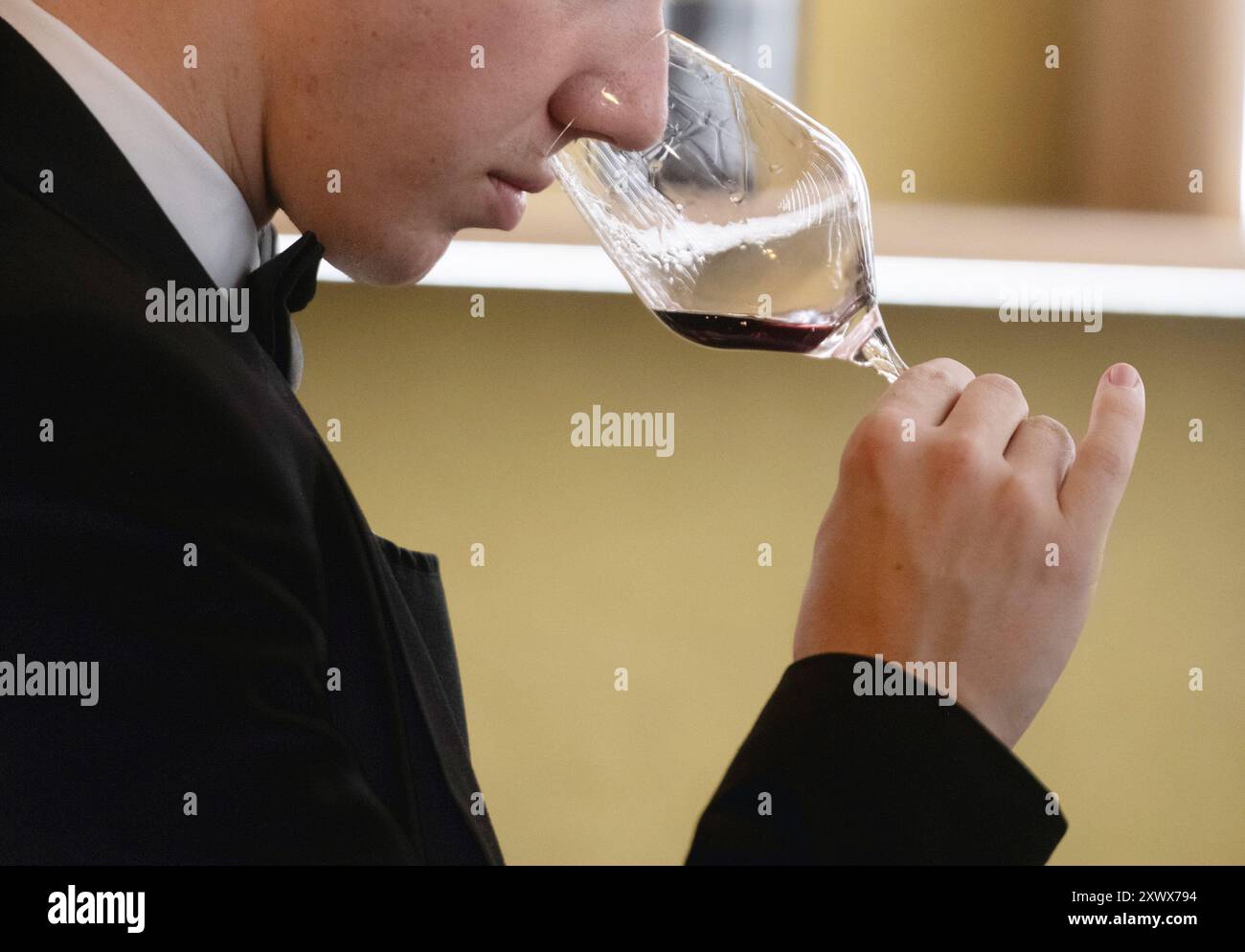Kellner in einem Restaurant, der die Aromen eines Glases Rotwein riecht Stockfoto