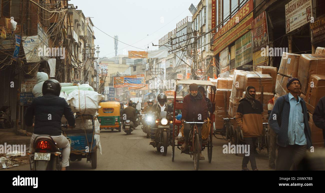 Neu-Delhi, Delhi, Indien. Verkehr auf dem Kucha Pati RAM, Chandni Chowk Street. Autos, Motorräder, Rikscha oder Tuk-Tuk, die sich am nebeligen Morgen auf der Straße bewegen Stockfoto