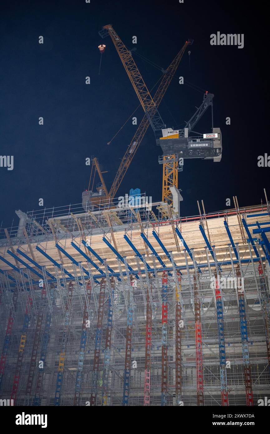 Nächtlicher Blick auf die Baustelle des Amazonasturms in Berlin, mit beleuchteten Kränen und Gerüsten. Dieses Bild steht für Fortschritt, moderne Architektur und städtische Entwicklung. Stockfoto