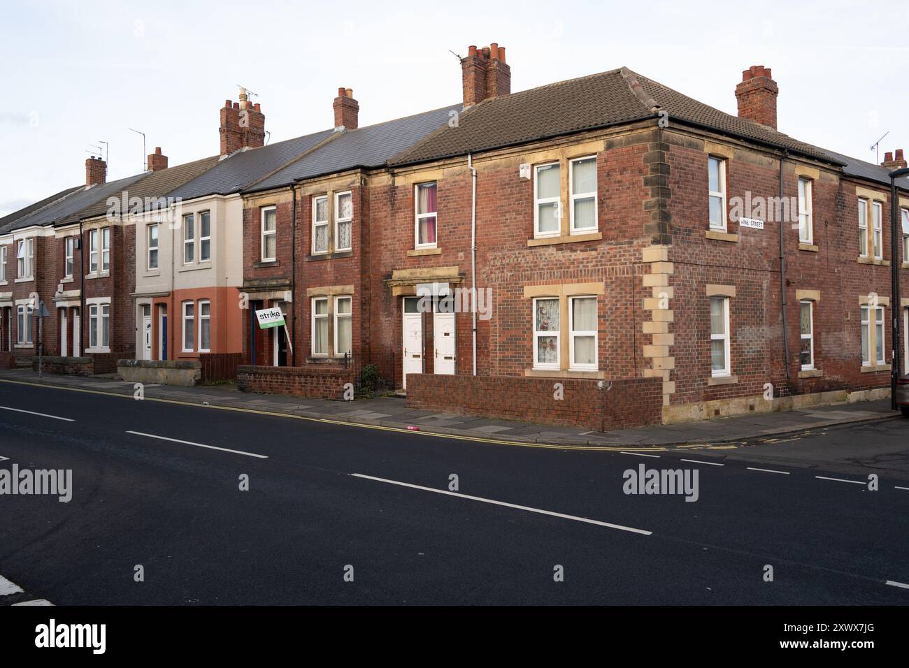 Eine Reihe traditioneller Backsteinterrassenhäuser, die entlang einer ruhigen Wohnstraße in Wallsend, Newcastle upon Tyne, liegen. Das Bild fängt die zeitlose Architektur und die ruhige urbane Umgebung ein. Stockfoto