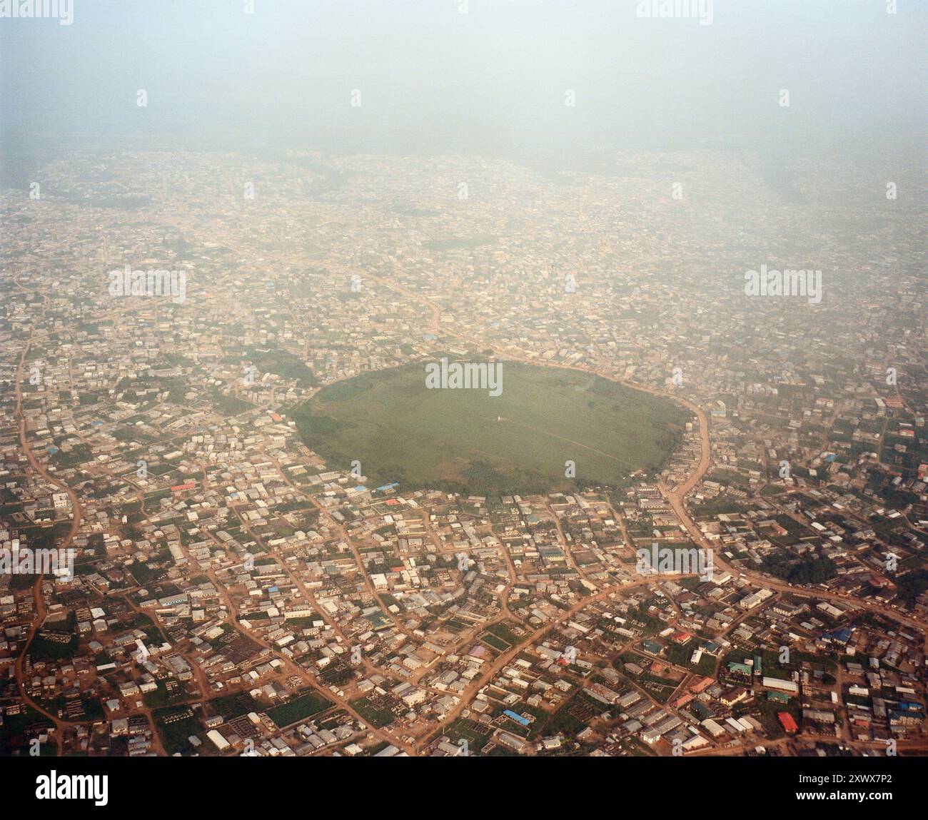 Luftaufnahme, die die weitläufige Stadtlandschaft von Lagos, Nigeria, mit einem markanten Grünbereich im Zentrum feststellt. Dieses Bild aus dem Jahr 2009 zeigt die städtische Dichte und die natürlichen Gebiete der Stadt. Stockfoto