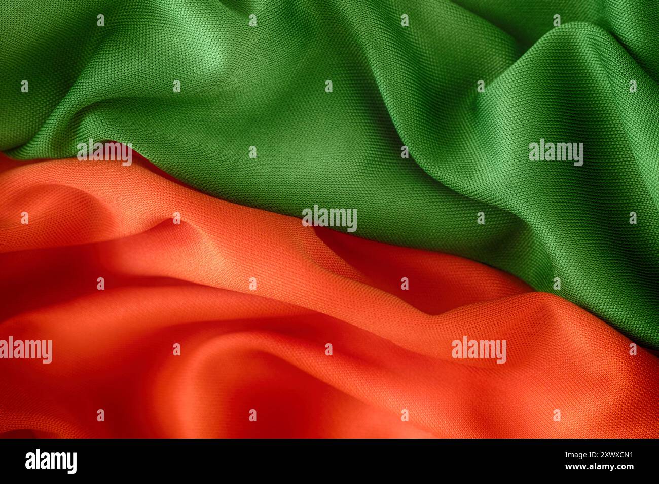 Hintergrund aus rotem Orange und grünem Stoff. Nahaufnahme. Stockfoto