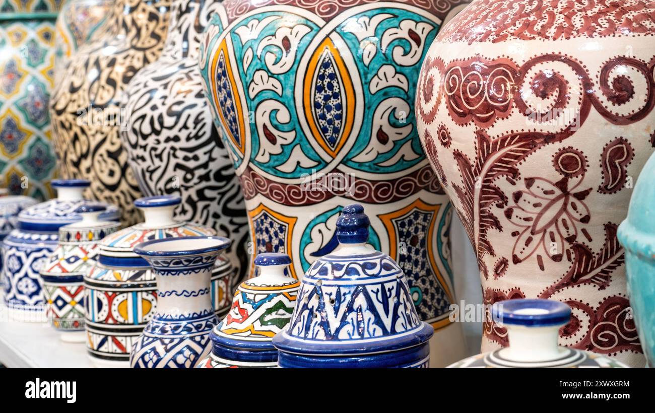 Farbenfrohe marokkanische Töpferwaren und Keramiken, die vor den Geschäften in den Souks ausgestellt werden und traditionelle Designs und Handwerkskunst zeigen. Stockfoto