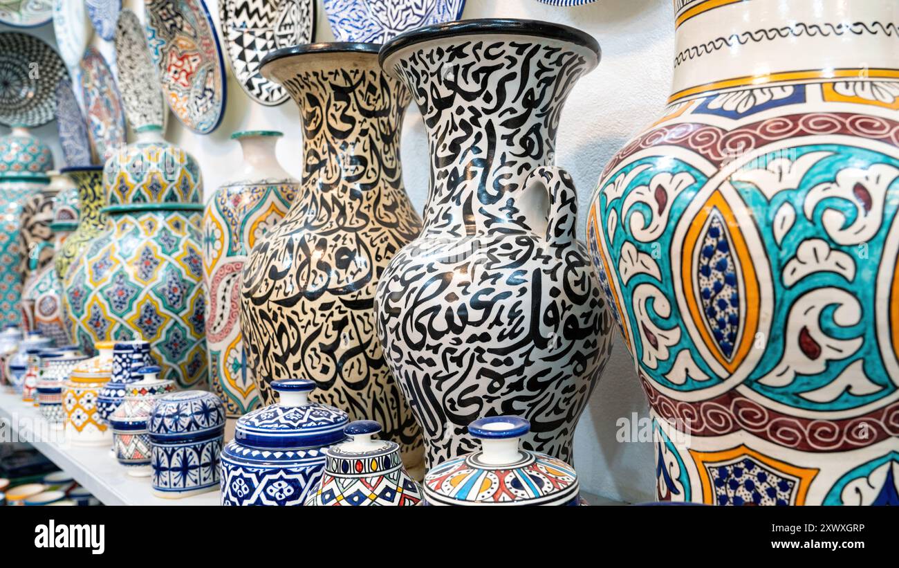 Farbenfrohe marokkanische Töpferwaren und Keramiken, die vor den Geschäften in den Souks ausgestellt werden und traditionelle Designs und Handwerkskunst zeigen. Stockfoto