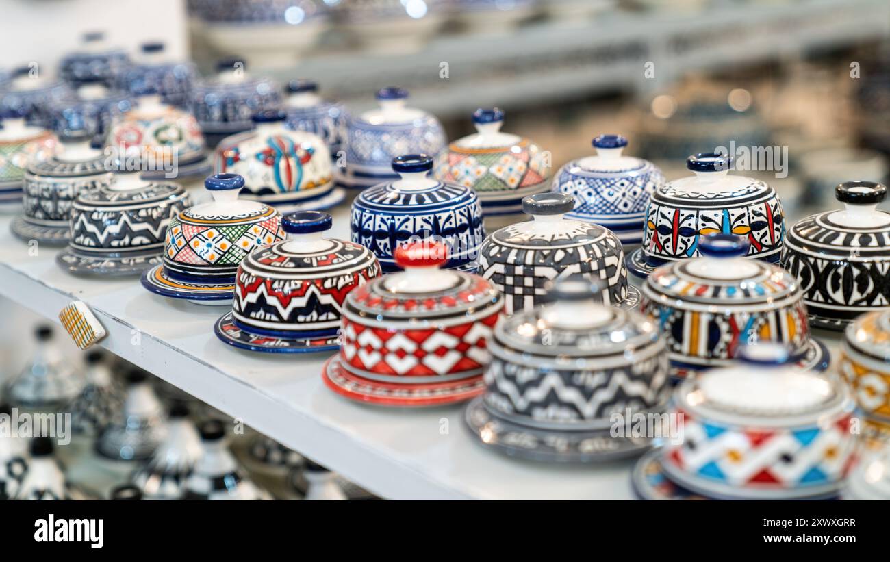 Farbenfrohe marokkanische Töpferwaren und Keramiken, die vor den Geschäften in den Souks ausgestellt werden und traditionelle Designs und Handwerkskunst zeigen. Stockfoto