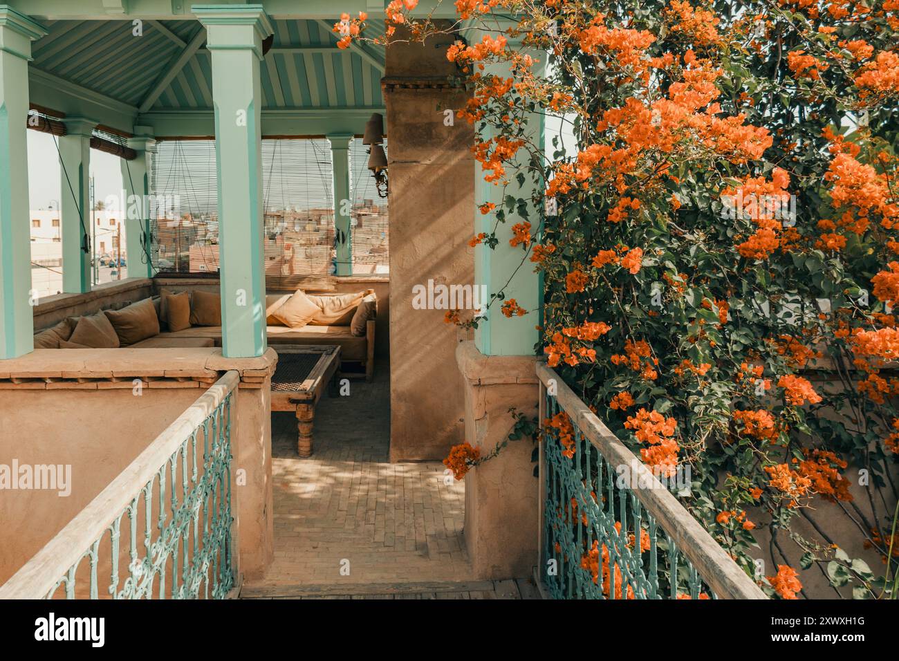 Charmante Dachterrasse des Riad mit Bougainvillea-Blumen, rustikalem Luxus-Architekturstil, sanften Schatten, ruhigem und bezauberndem Sitzbereich im Freien, Stockfoto