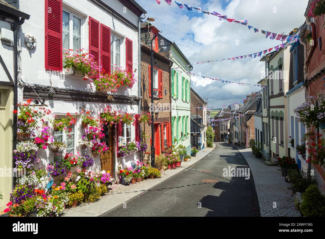 Helle Blumen vor alten traditionellen Häusern in der Rue des Moulins, St. Valery sur Somme, Somme, Picardy, Frankreich Stockfoto