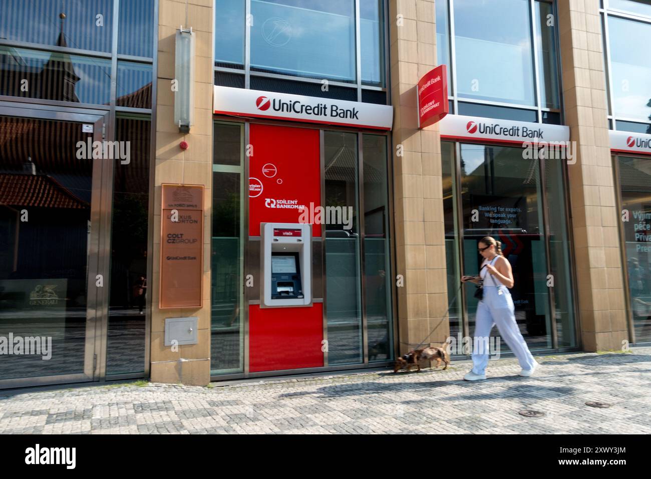 UniCredit Bank Logo Company, Street Scene View, Woman Walk with Dog Geldautomat Prag Tschechische Republik Stockfoto