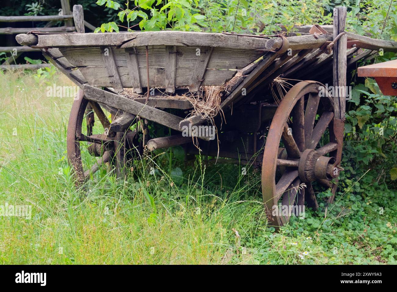 Traditionelles Landfahrzeug im Naturhintergrund. Vintage Holzwagen. Holzräder. Stockfoto