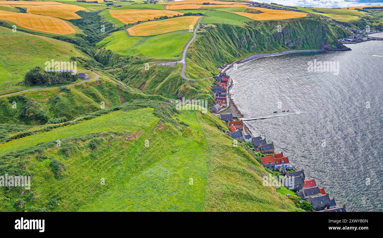 Crovie Aberdeenshire Schottland goldene Gerstenfelder im Sommer über den roten Dächern der Häuser Stockfoto