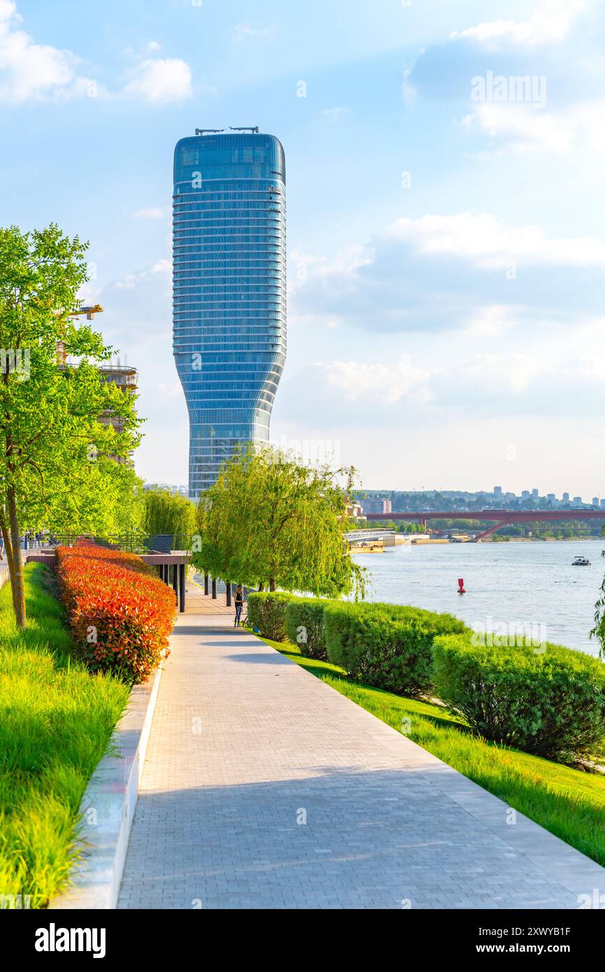 Ein herrlicher Blick auf den Belgrader Turm entlang des Flusses, umgeben von üppigem Grün und bunten Büschen, die die lebhafte Atmosphäre der Gegend an einem sonnigen Tag einfangen. Stockfoto