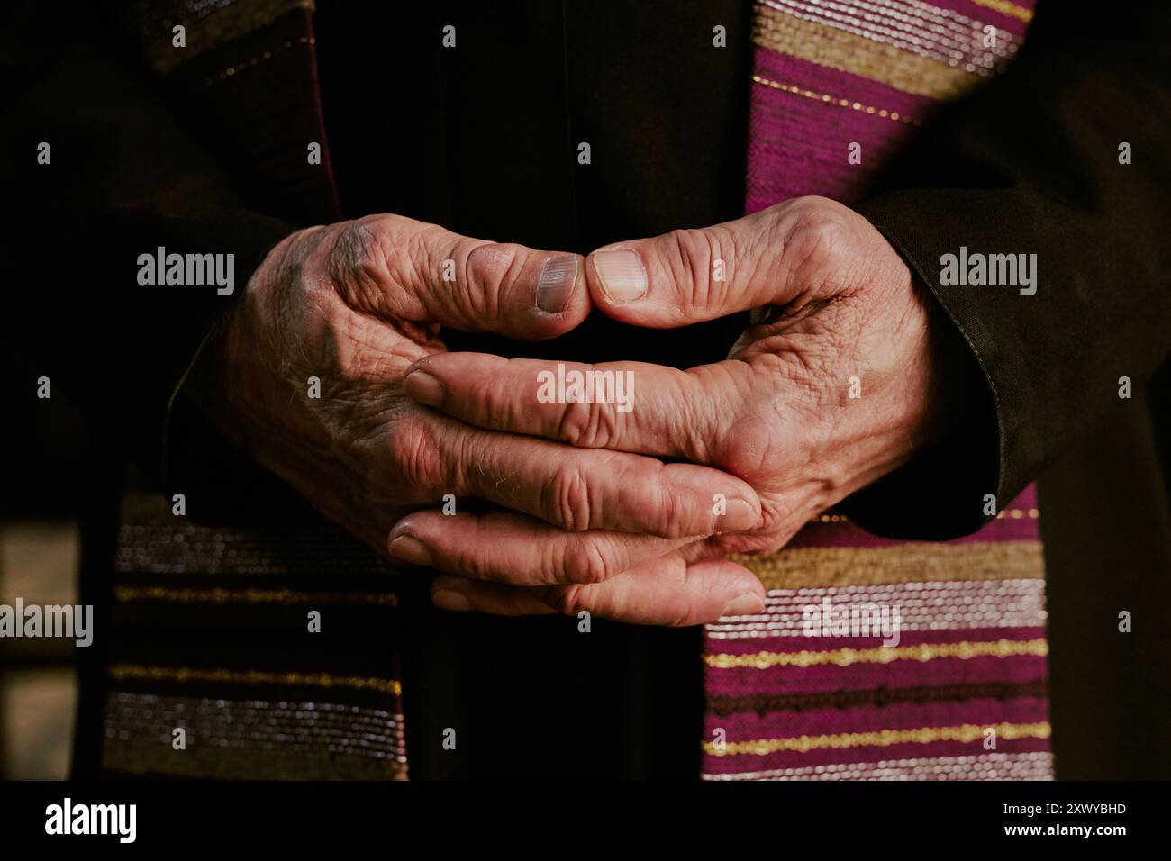 Mittlere Nahaufnahme faltiger, nicht erkennbarer männlicher Hände des Priesters Stockfoto