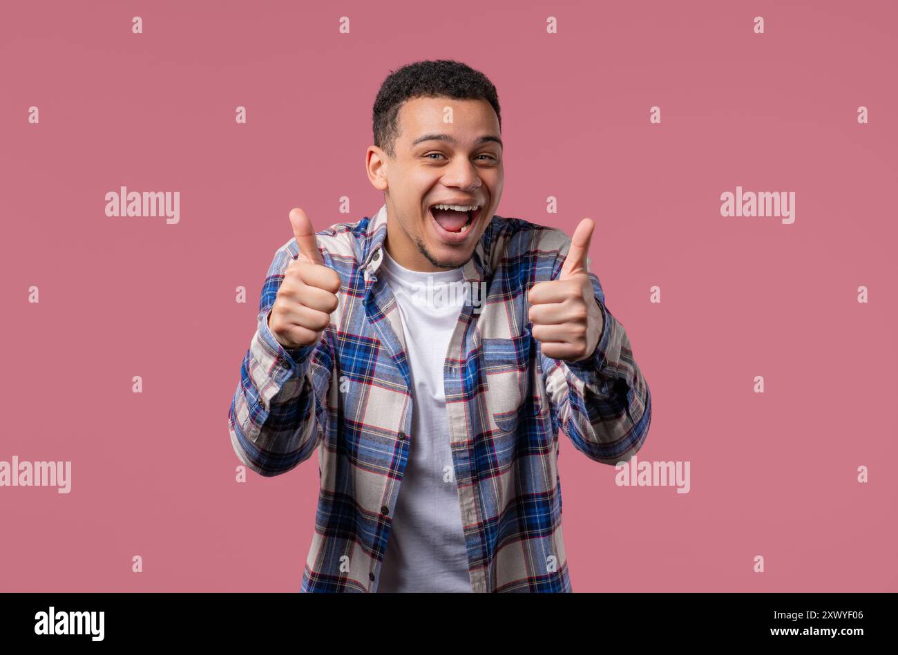 Positiver, stilvoller birassischer Mann mit ÄHNLICHEM Schild, Daumen hoch Geste. Happy Hipster. Stockfoto