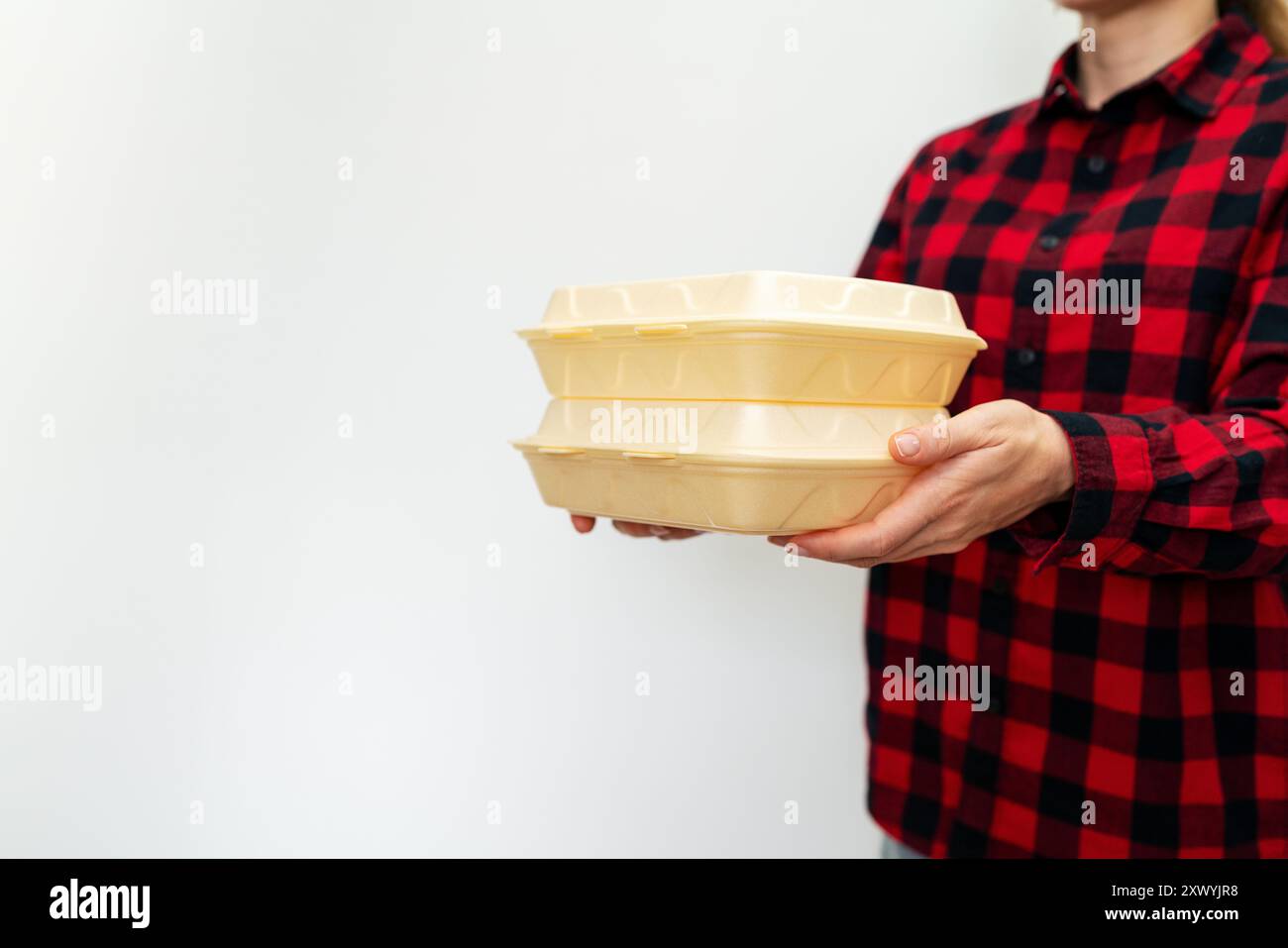 Einwegfutterbehälter in weiblichen Händen Stockfoto