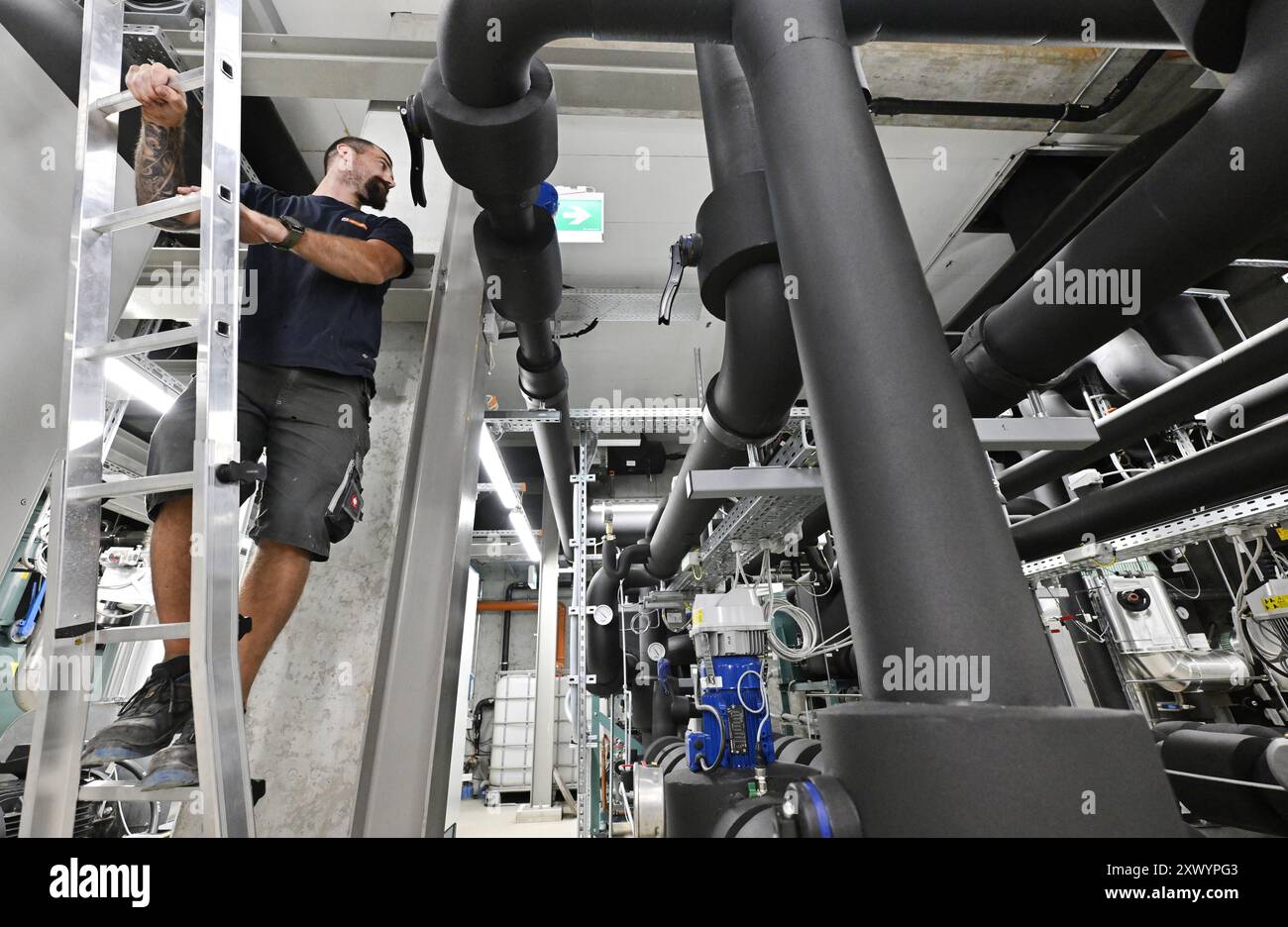 THEMENBILD - Projekt "Bild der Zukunft": FERNKÜHLUNG - mit Fernwärme wird kaltes Wasser in einem geschlossenen Kreislauf über ein Netz isolierter Rohre transportiert. Vor Ort absorbiert das Wasser Wärme und kühlt so die Raumtemperatur. Er fließt dann zurück und wird zentral wieder gekühlt. Schließlich wird das auf rund 5-6 Grad gekühlte Wasser über den Fernkühlring (Kühlnetz) in das parlamentsgebäude geleitet. Dort wird die Temperatur über Deckenkühlung, Bodenkühlung oder Luftauslässe geregelt. Das Foto wurde am 22. Juli 2024 aufgenommen. Ein Angestellter in einem Wiener Energiebezirk Kühlung Stockfoto