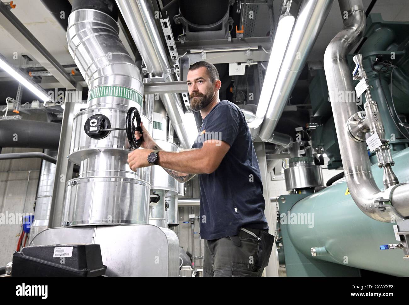 THEMENBILD - Projekt "Bild der Zukunft": FERNKÜHLUNG - mit Fernwärme wird kaltes Wasser in einem geschlossenen Kreislauf über ein Netz isolierter Rohre transportiert. Vor Ort absorbiert das Wasser Wärme und kühlt so die Raumtemperatur. Er fließt dann zurück und wird zentral wieder gekühlt. Schließlich wird das auf rund 5-6 Grad gekühlte Wasser über den Fernkühlring (Kühlnetz) in das parlamentsgebäude geleitet. Dort wird die Temperatur über Deckenkühlung, Bodenkühlung oder Luftauslässe geregelt. Das Foto wurde am 22. Juli 2024 aufgenommen. Ein Angestellter in einem Wiener Energiebezirk Kühlung Stockfoto
